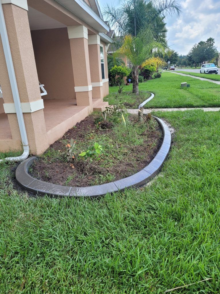 A lawn with a concrete curb in front of a house.