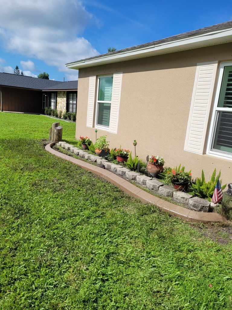 A house with a lawn and flowers in front of it.