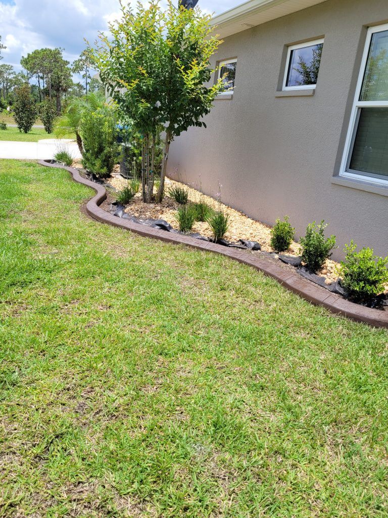 A house with a lush green lawn and bushes in front of it.