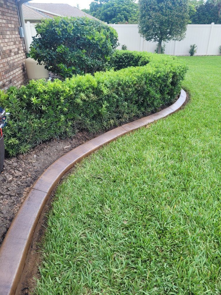 There is a concrete curb in the middle of the lawn.