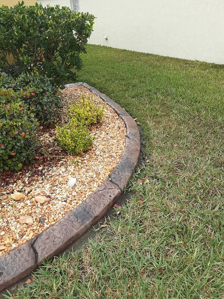 A lawn with a concrete curb and a rock garden.