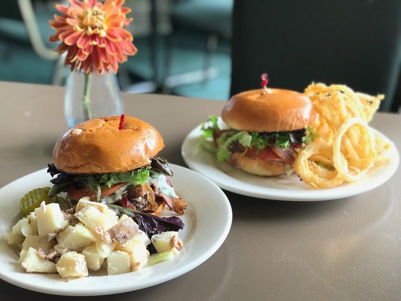 A man is talking to a group of people sitting at tables in a restaurant.