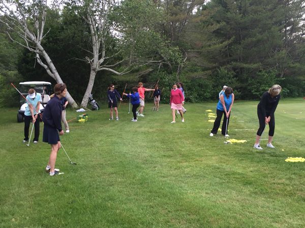 A group of people are playing golf on a golf course.