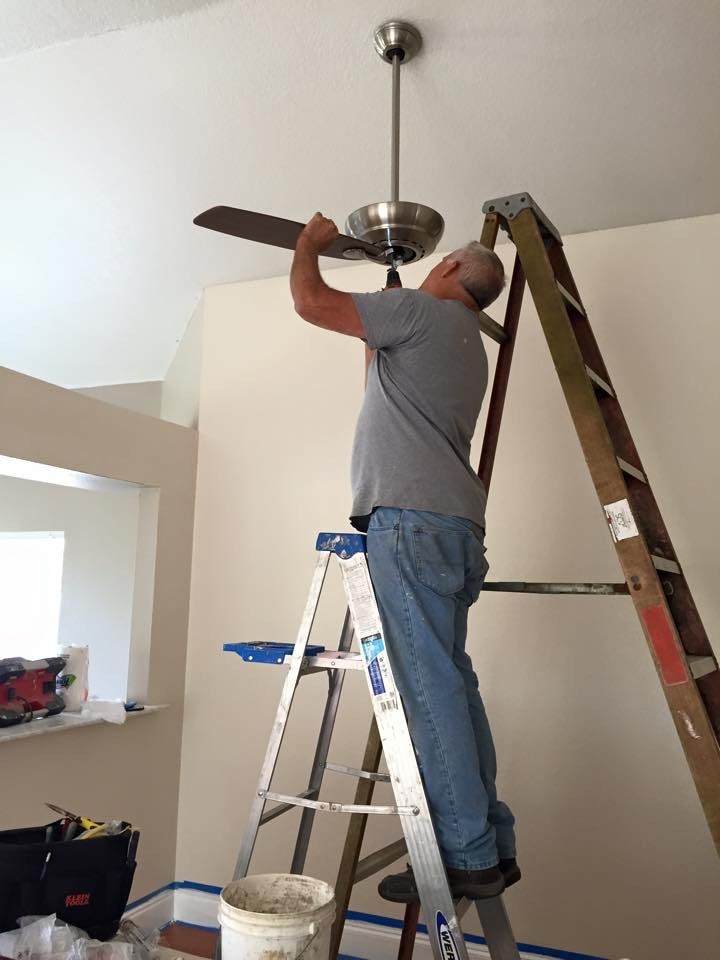 man installing a ceiling fan