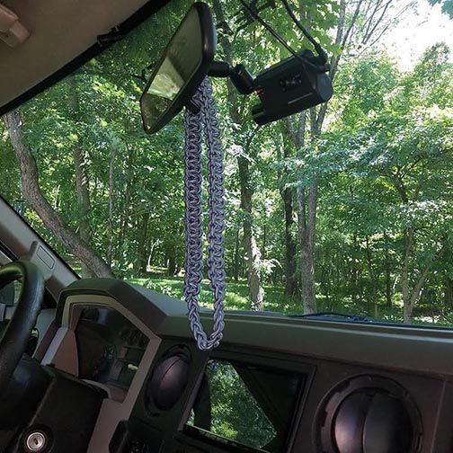 A rear view mirror is hanging from the dashboard of a car.