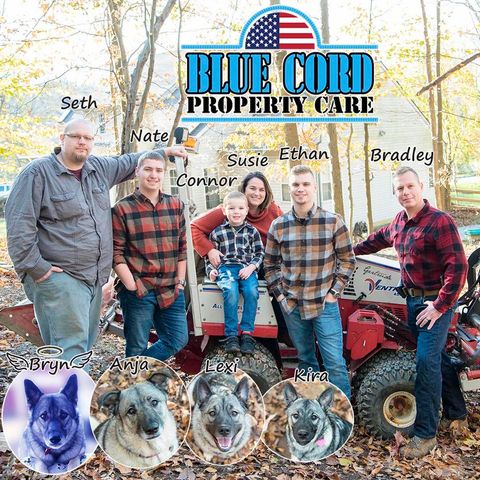 A group of people standing in front of a blue cord property care truck