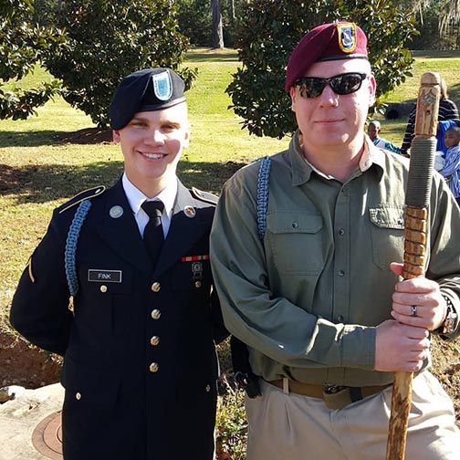 Two men in military uniforms are posing for a picture