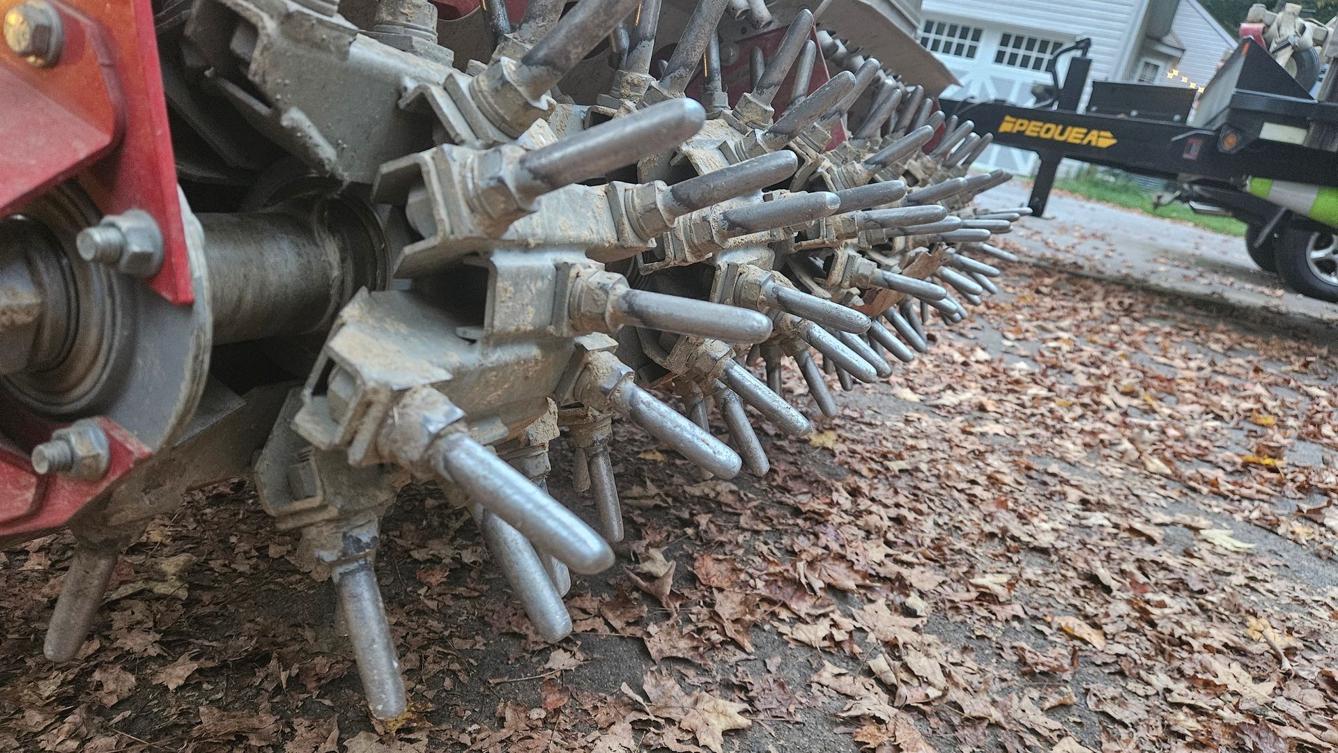 A close up of a machine with leaves on the ground.