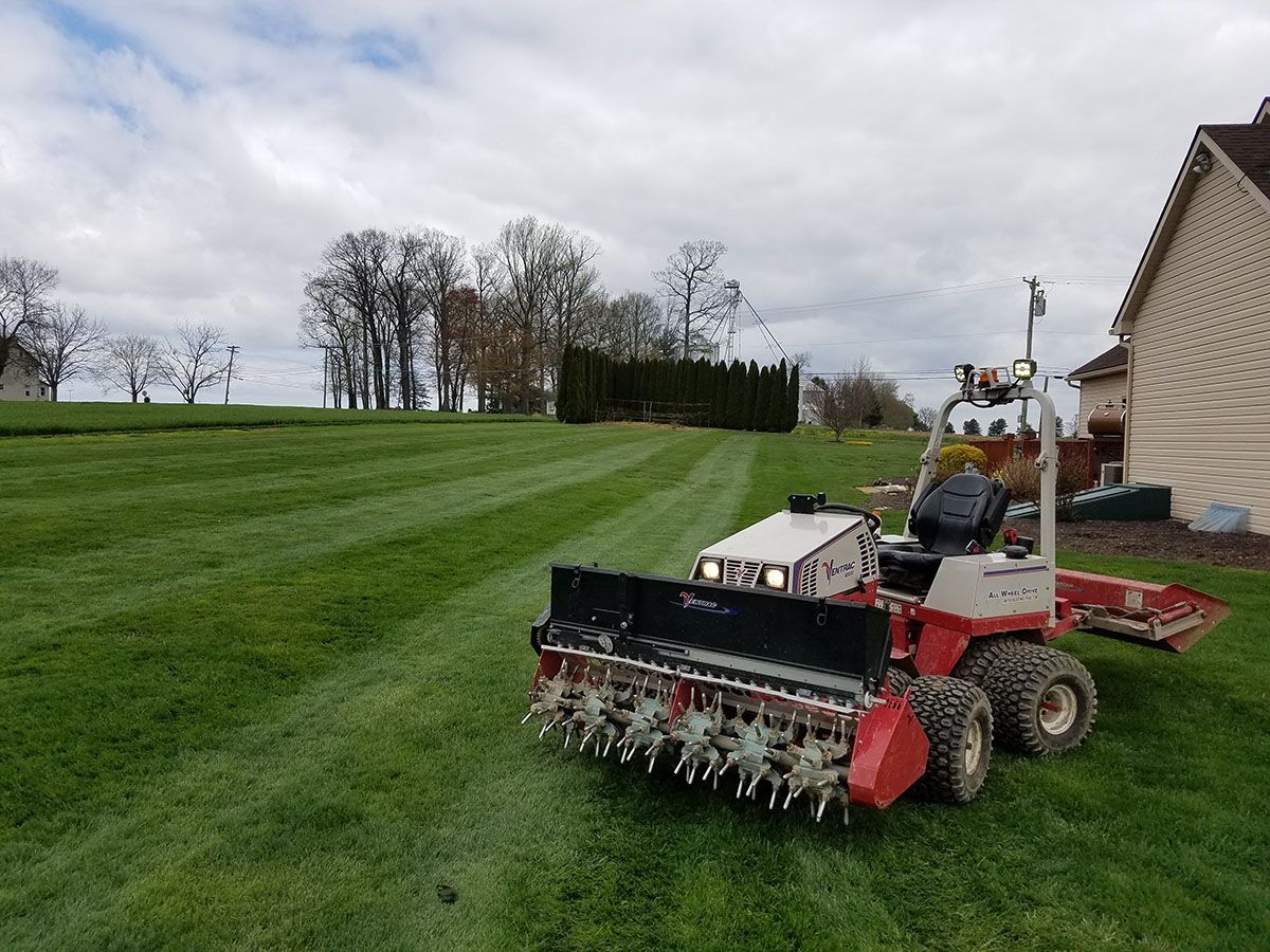 A lawn mower is sitting on top of a lush green lawn.