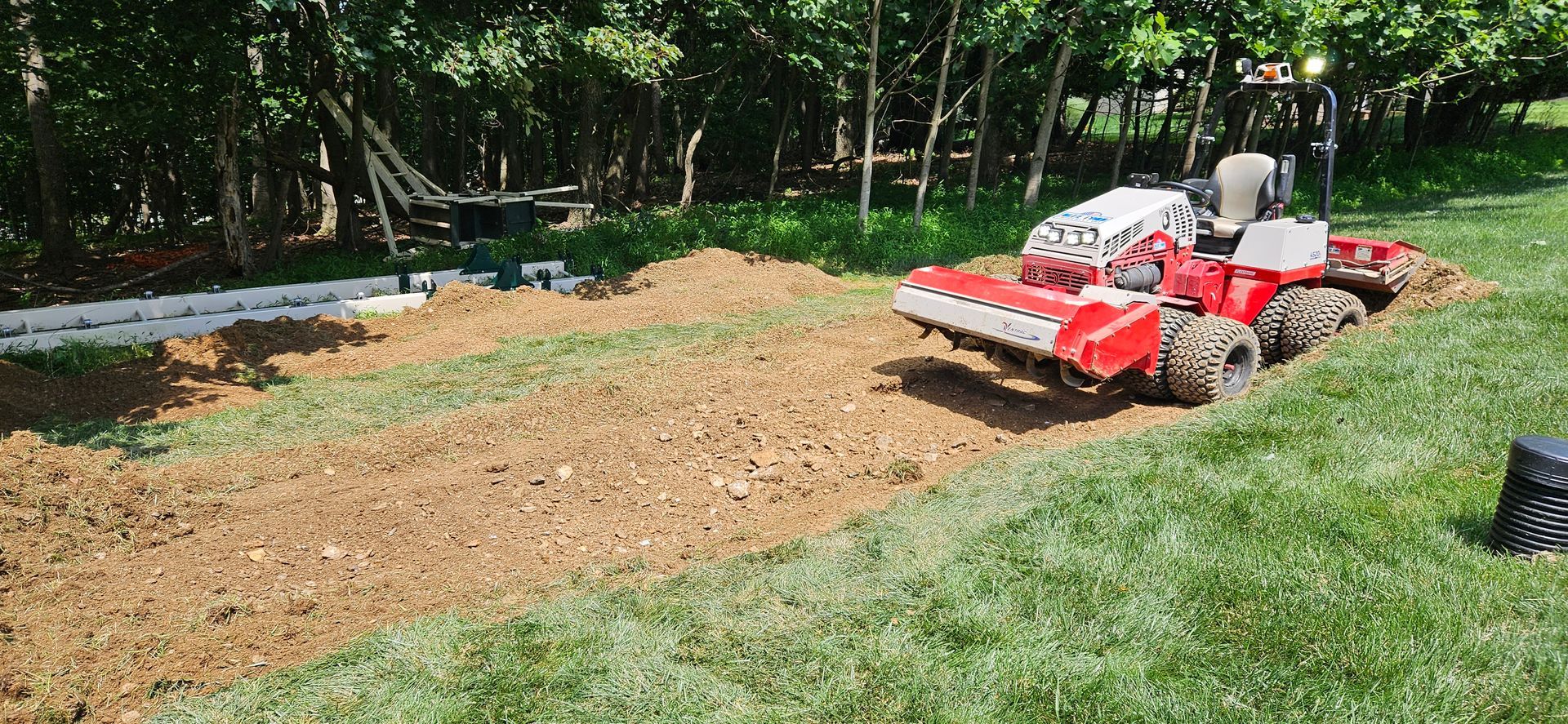 A red and white tractor is sitting on top of a lush green lawn.