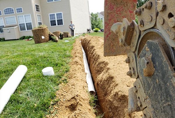 A man is standing in the grass in front of a house.