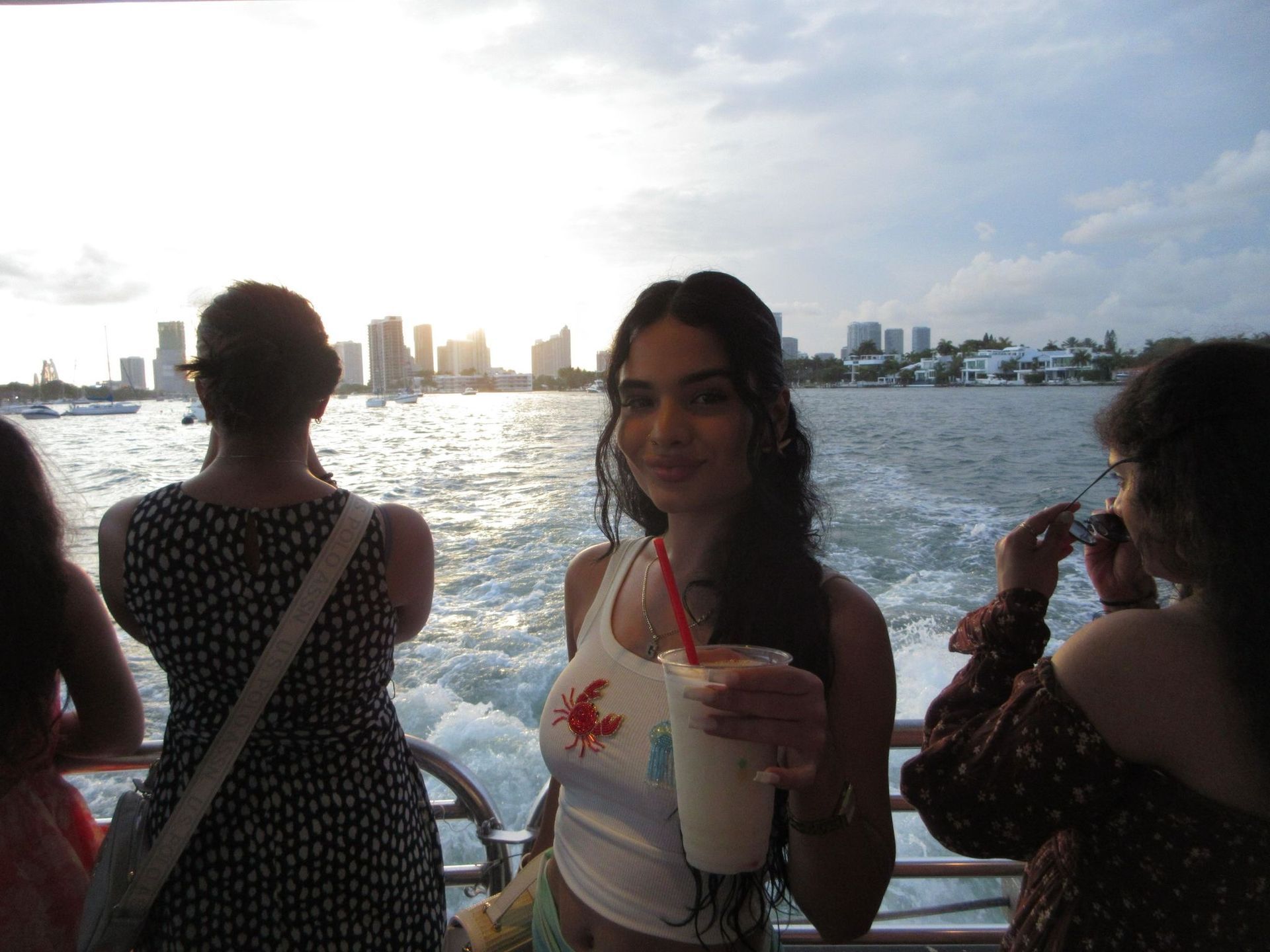 Miami Star Island Boat Tour with the Miami Skyline in the background, passenger with a drink in her hand