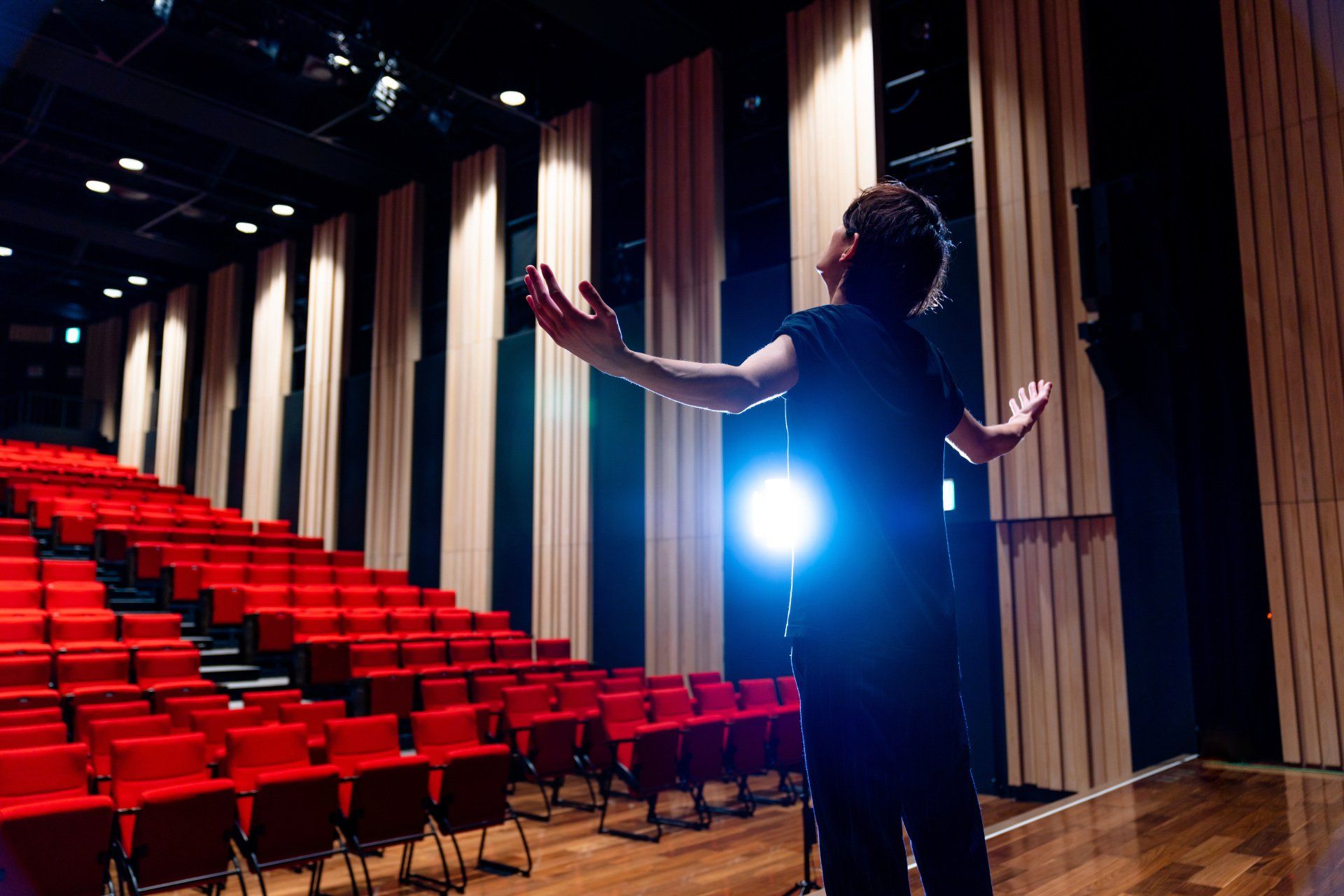 A young person practicing a speech to an empty theatre