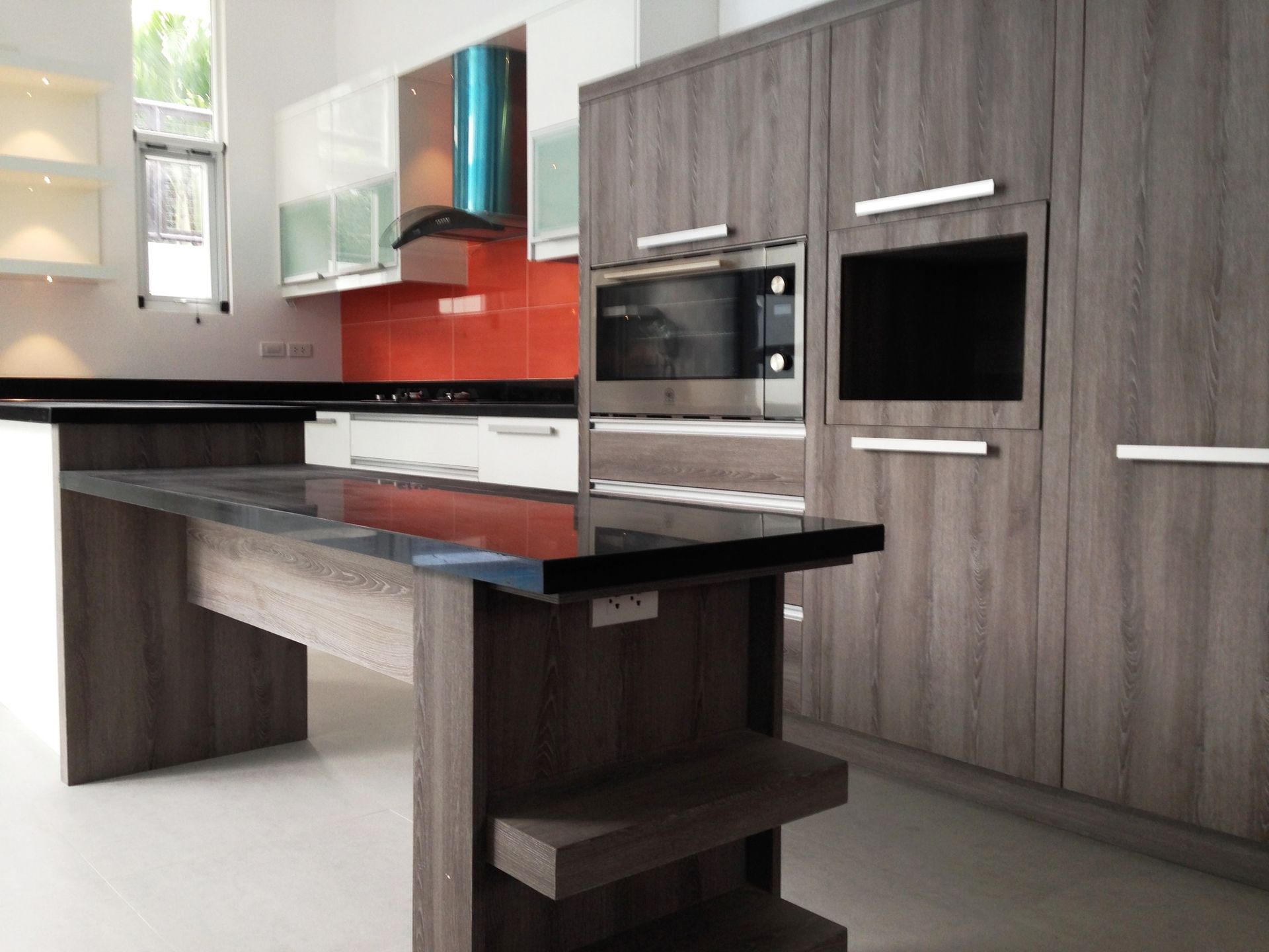 Modern Kitchen With Cabinets, Black Countertops, and Orange Backsplash — ModulPlus in Burrum Heads, QLD