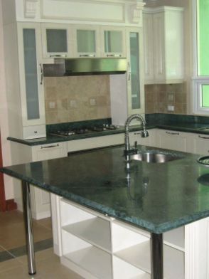 A Kitchen With a Green Counter Top and White Cabinets — ModulPlus in Hervey Bay, QLD