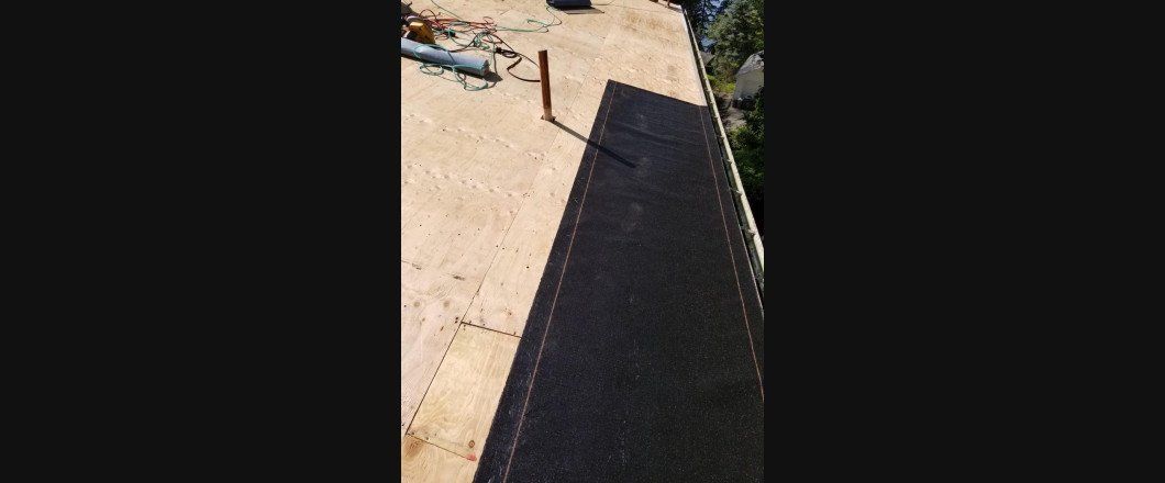 A close up of a piece of black carpet on a roof.