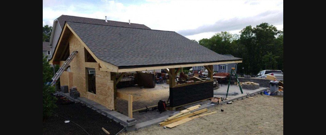 A small house is being built with a gray roof.