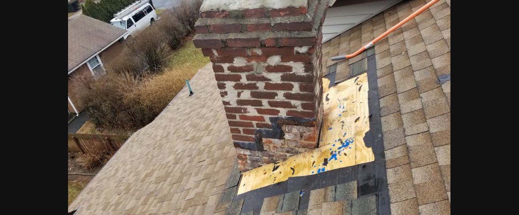 A brick chimney is sitting on top of a roof.