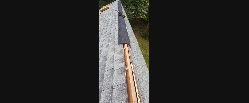 A close up of a roof with shingles being installed.