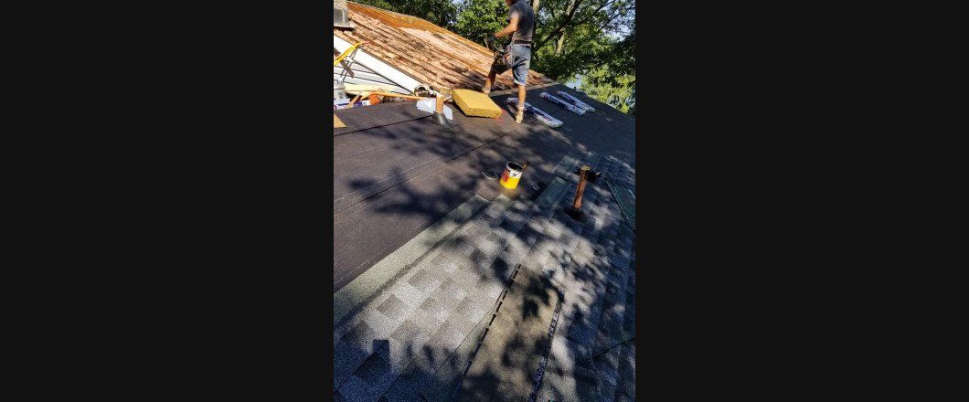 A man is standing on top of a pile of logs.