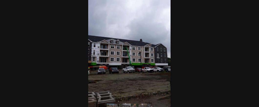 A large building with a lot of windows is being built on a cloudy day.