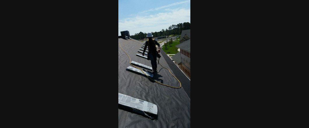 A person is walking on a roof with a skateboard.
