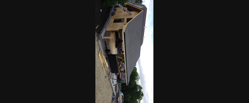 A house is being built with a gray roof.