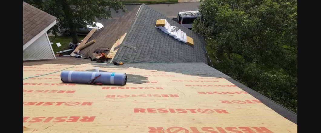 A roof with a roll of roofing material on it.