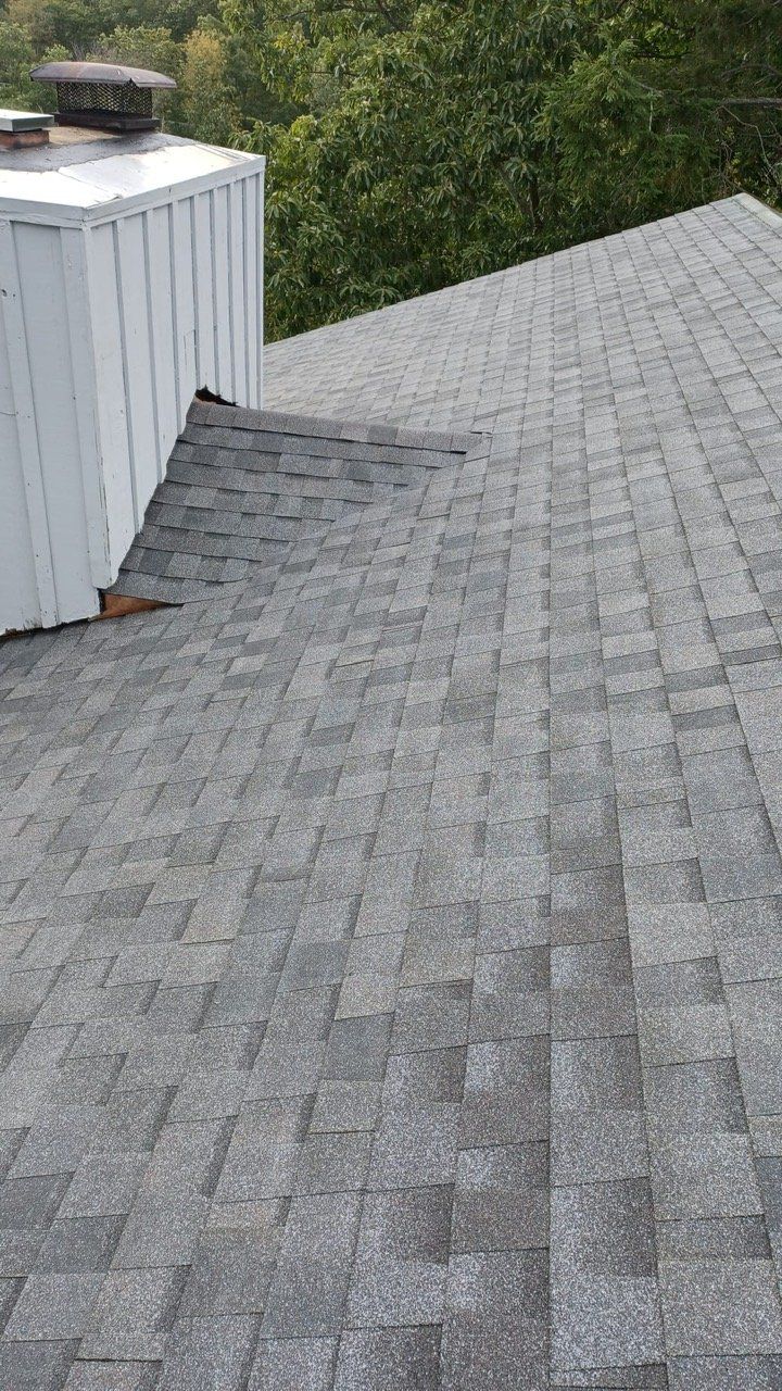 A close up of a roof with a chimney on top of it.