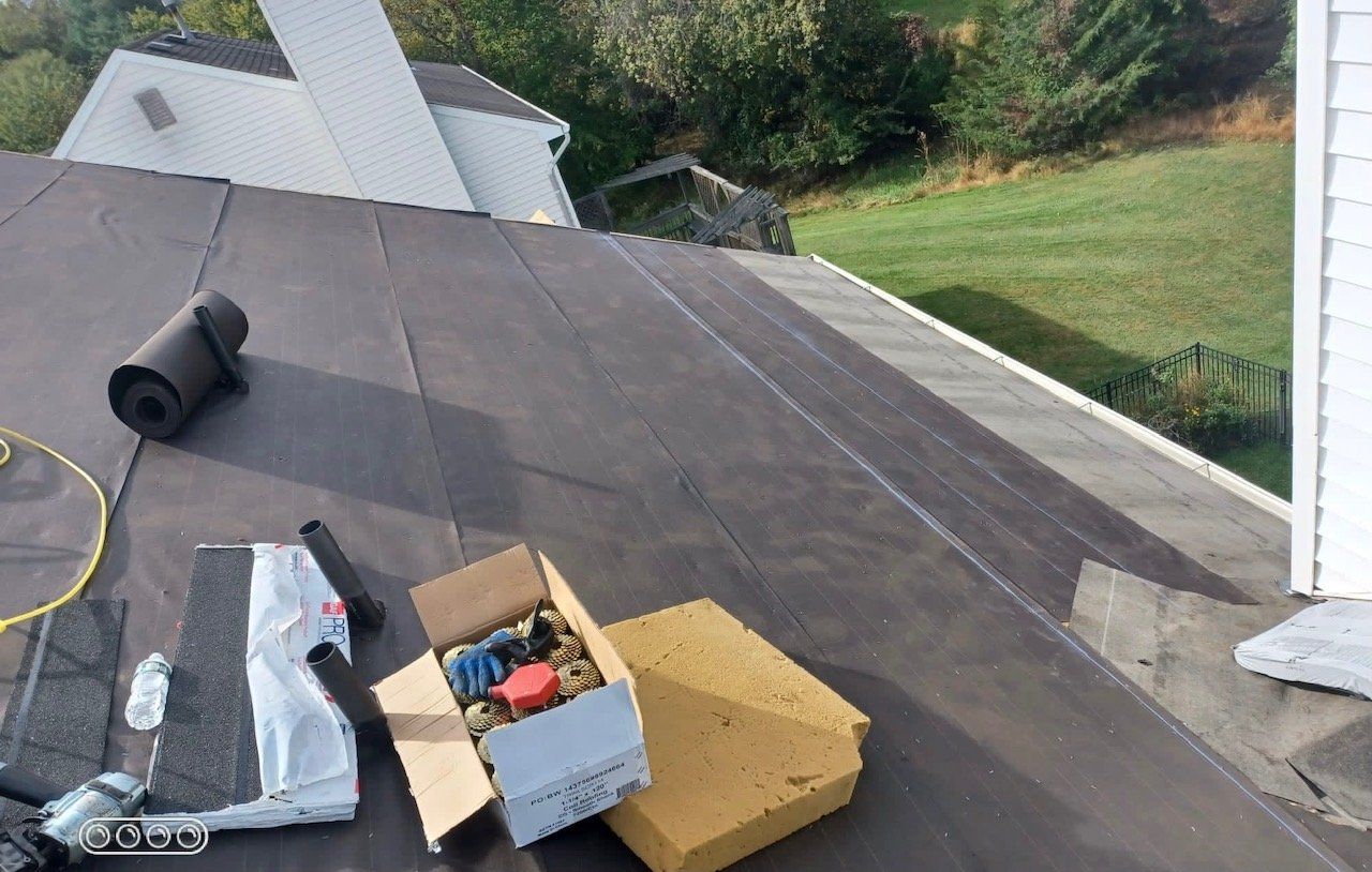 A box of tools is sitting on the roof of a house.