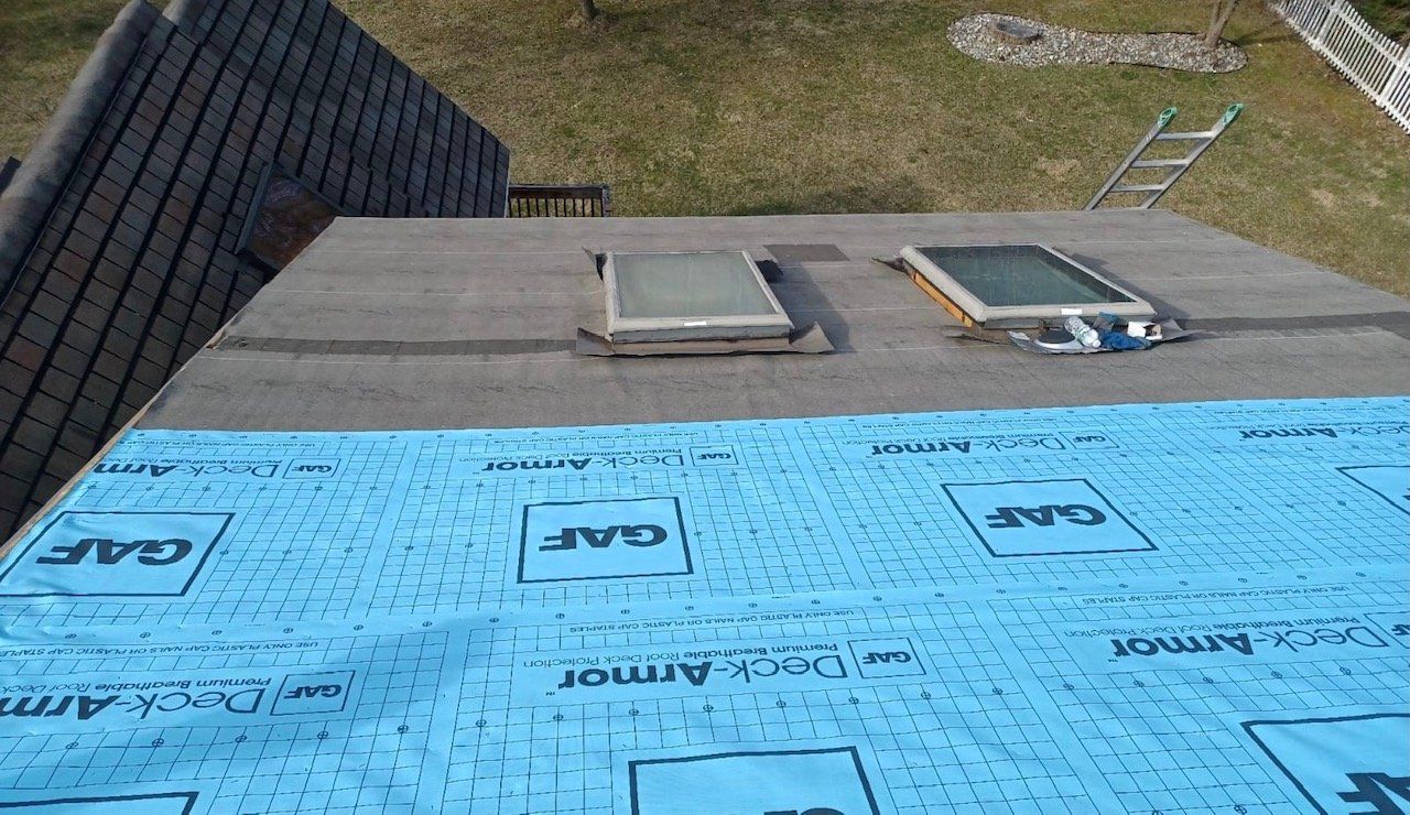 An aerial view of a roof with a ladder in the background