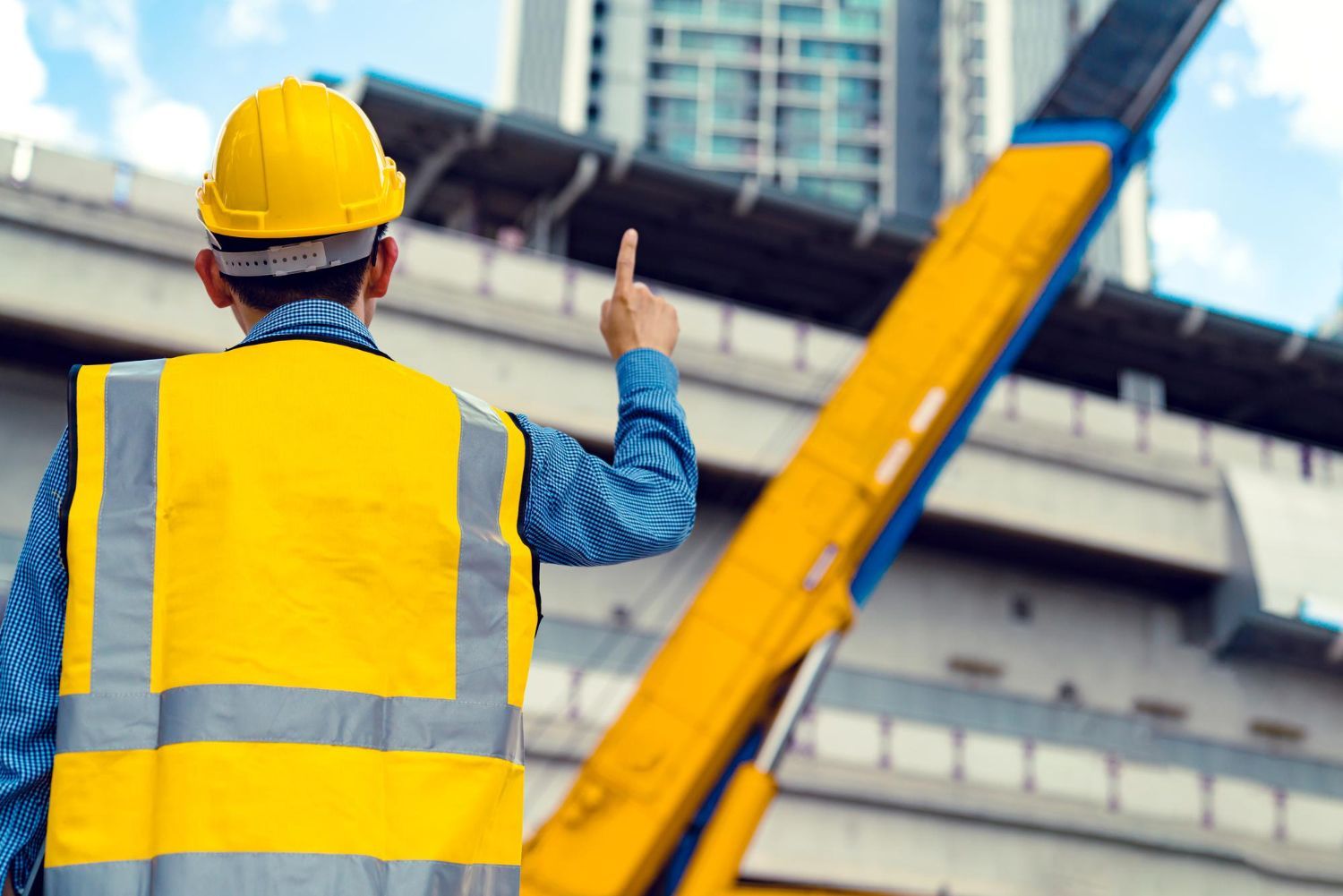 Construction worker overseeing site operations with heavy machinery