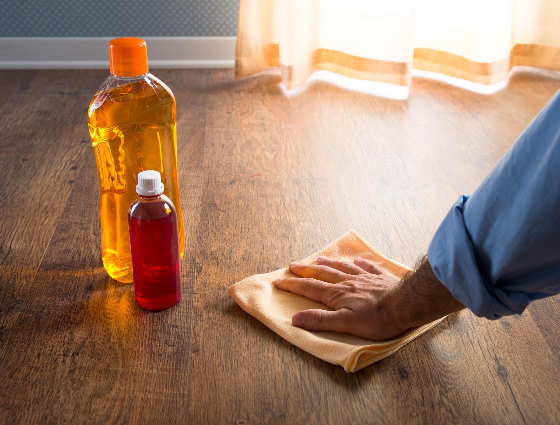 a person is cleaning a wooden floor with a cloth