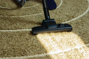 a person is using a vacuum cleaner to clean a carpet