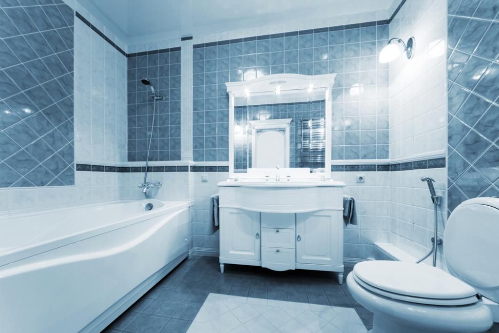 a bathroom with a toilet, sink, tub and mirror