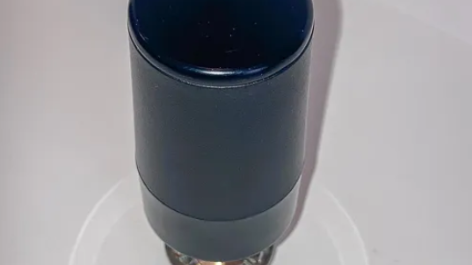 A blue bottle is sitting on top of a white plate.