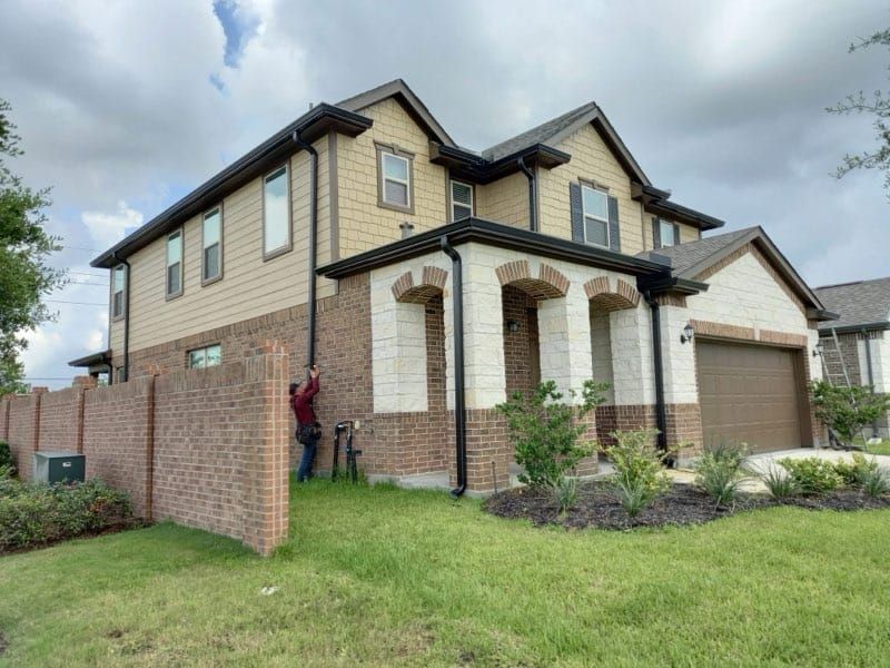 A man is standing in front of a large house.