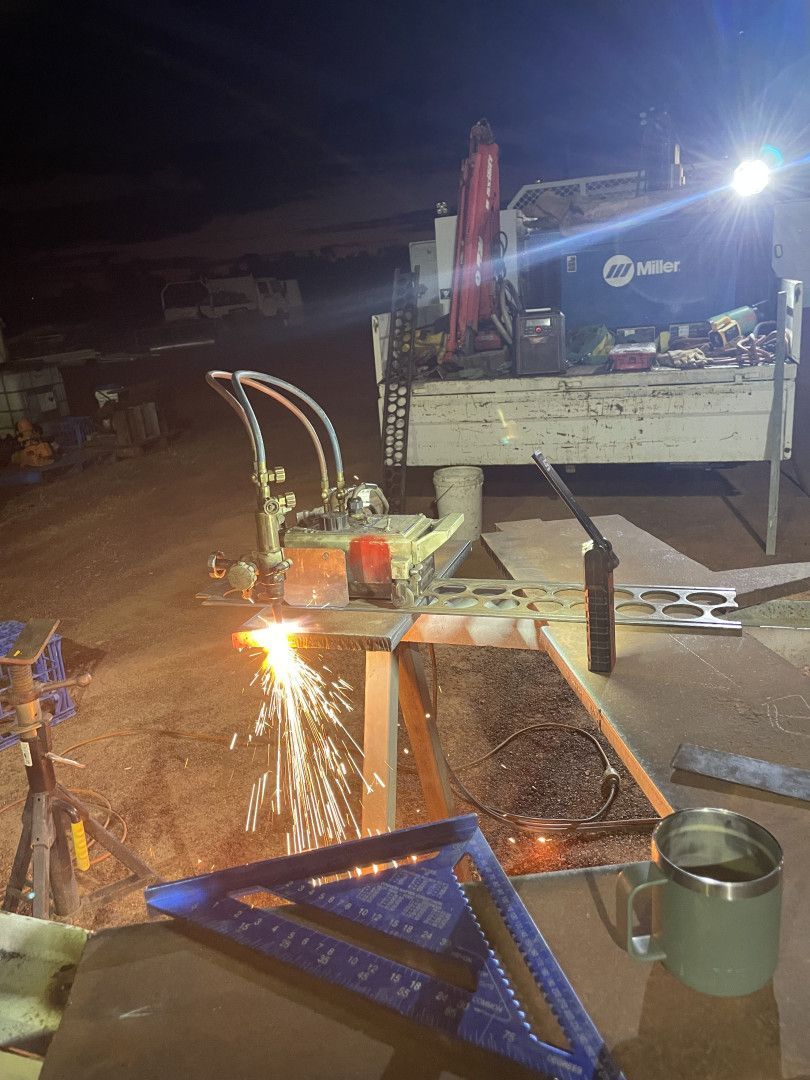 A Welder Using a Torch on Metal at Night — Lincoln Fabrication in Boulia, QLD