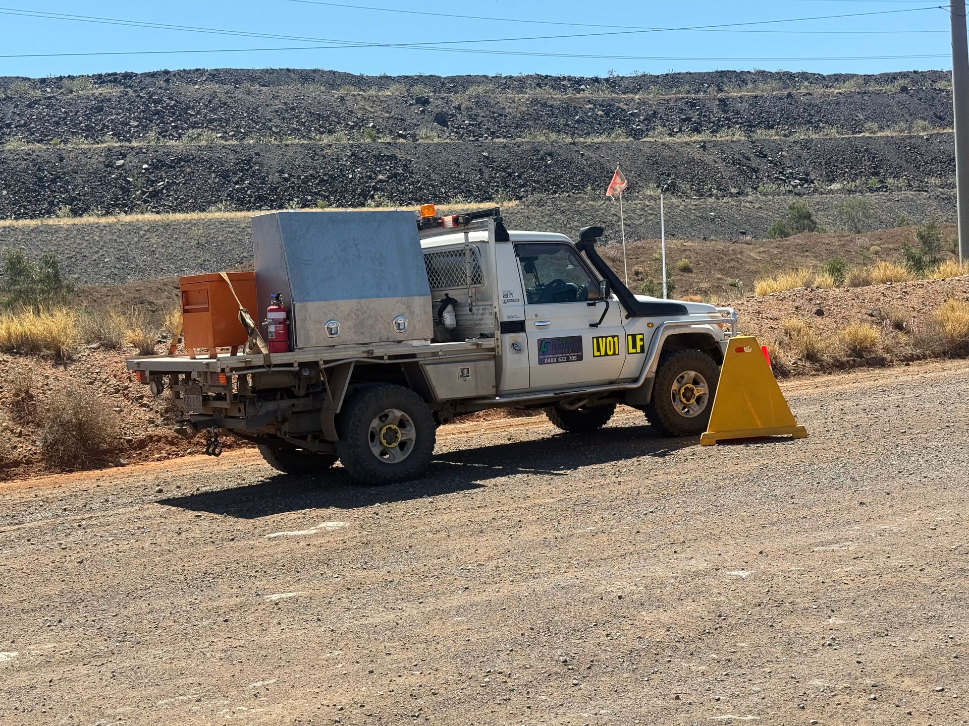 White Utility Truck With Storage on a Gravel Road, Near a Large Rock Pile — Lincoln Fabrication in Miles End, QLD