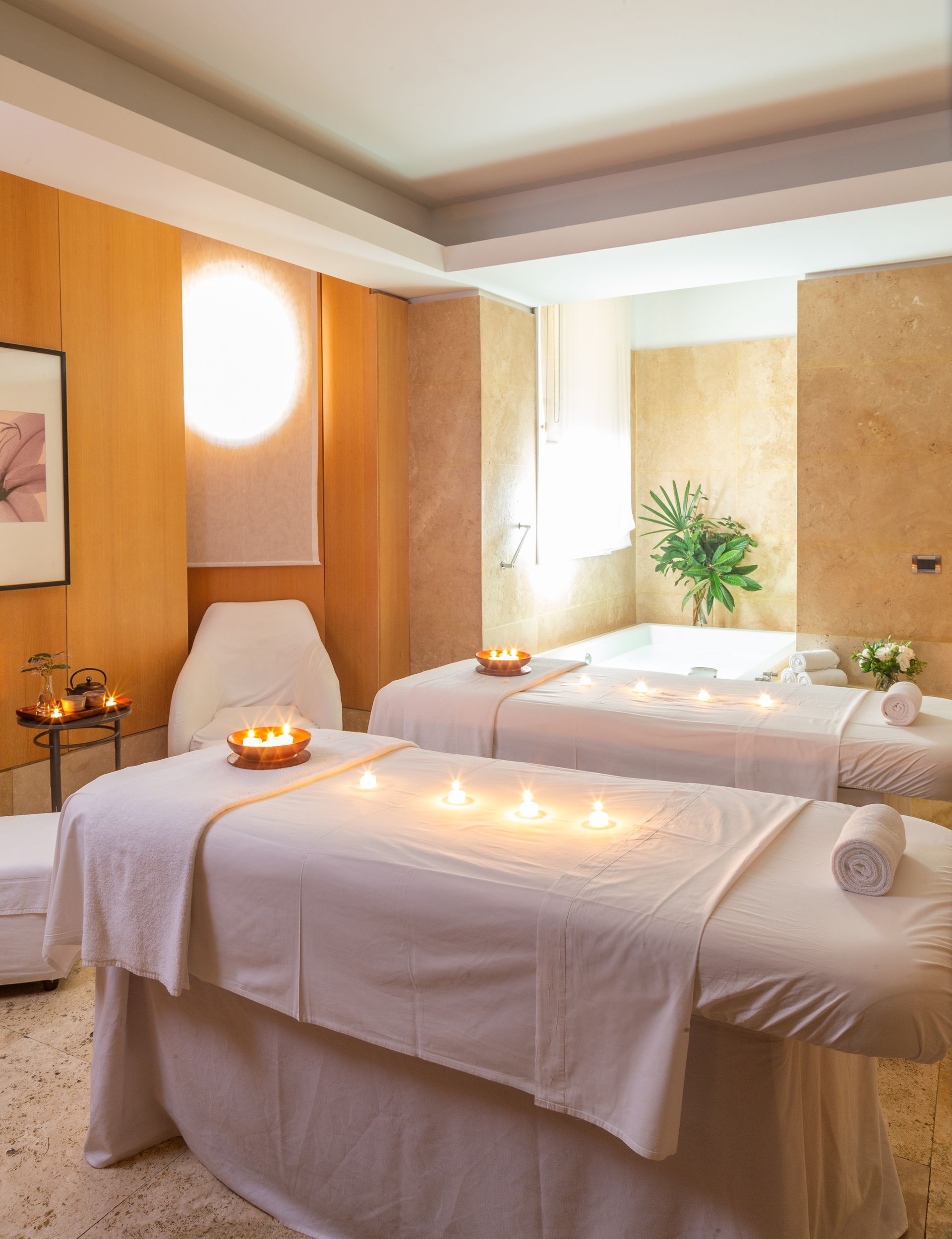 Dos mesas de masaje con velas en un spa.