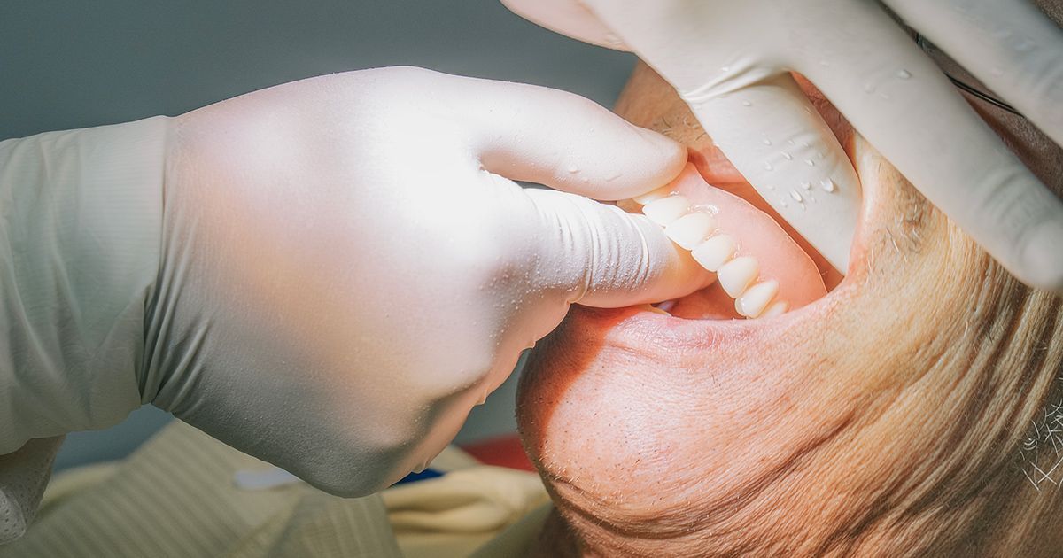 A dentist is examining a patient 's teeth in a dental office.