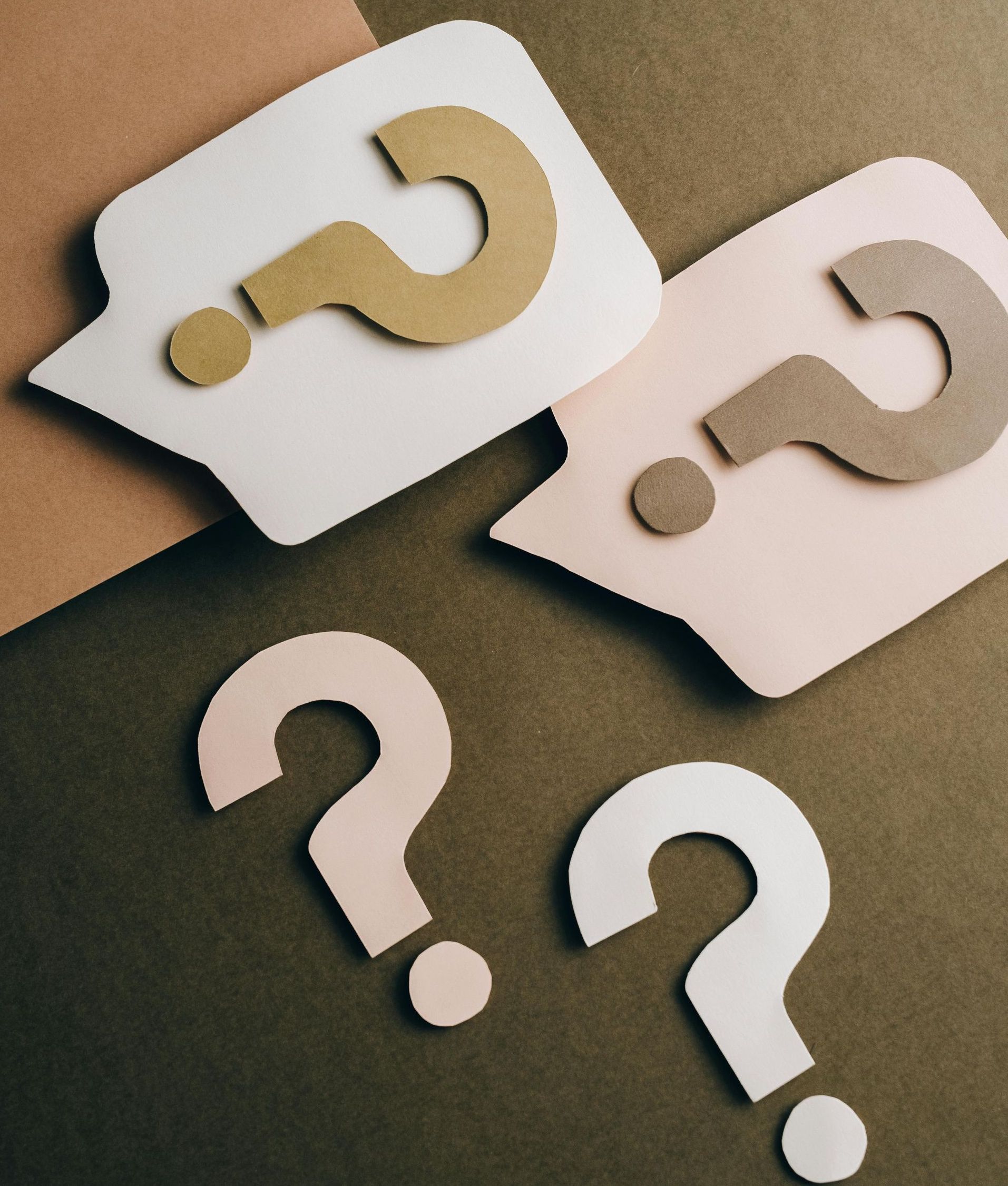 Two speech bubbles with question marks cut out of them