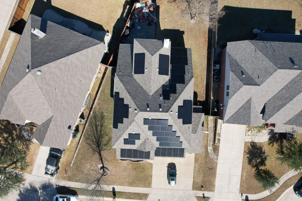 An aerial view of a house with solar panels on the roof