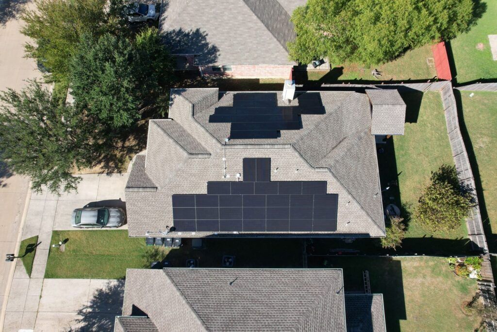 An aerial view of a house with solar panels on the roof