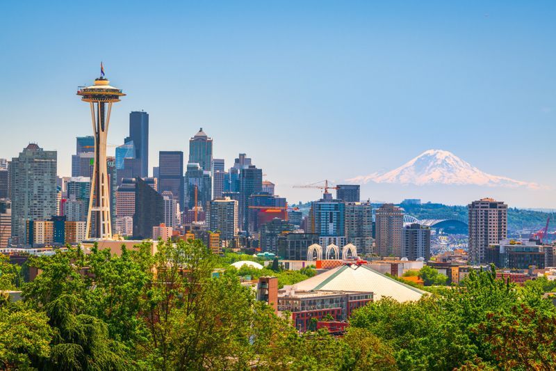A city skyline with a mountain in the background and a space needle in the foreground. A city skyline with a mountain in the background and a space needle in the foreground.