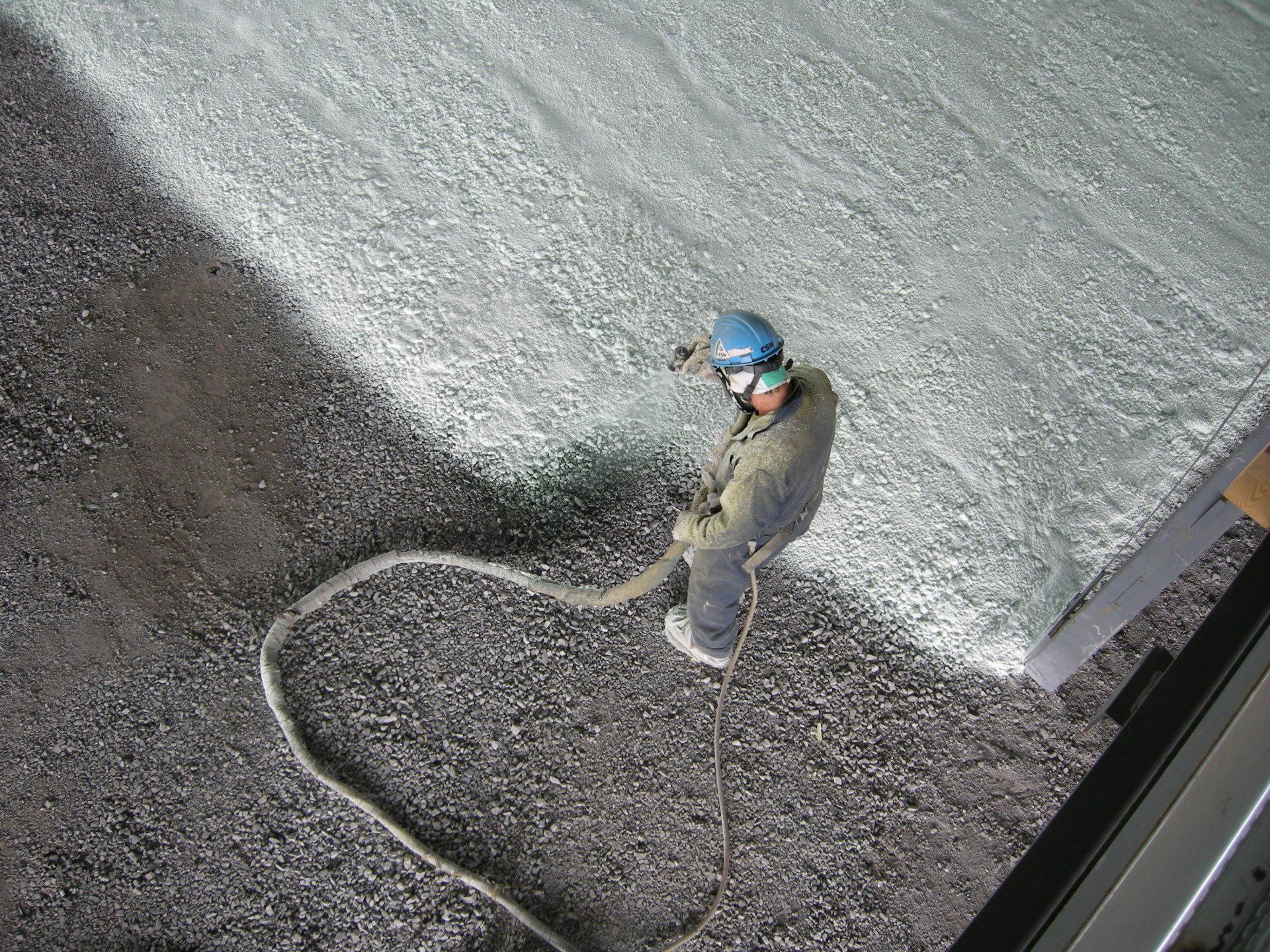 travailleur pulvérisant une couche de polyuréthane