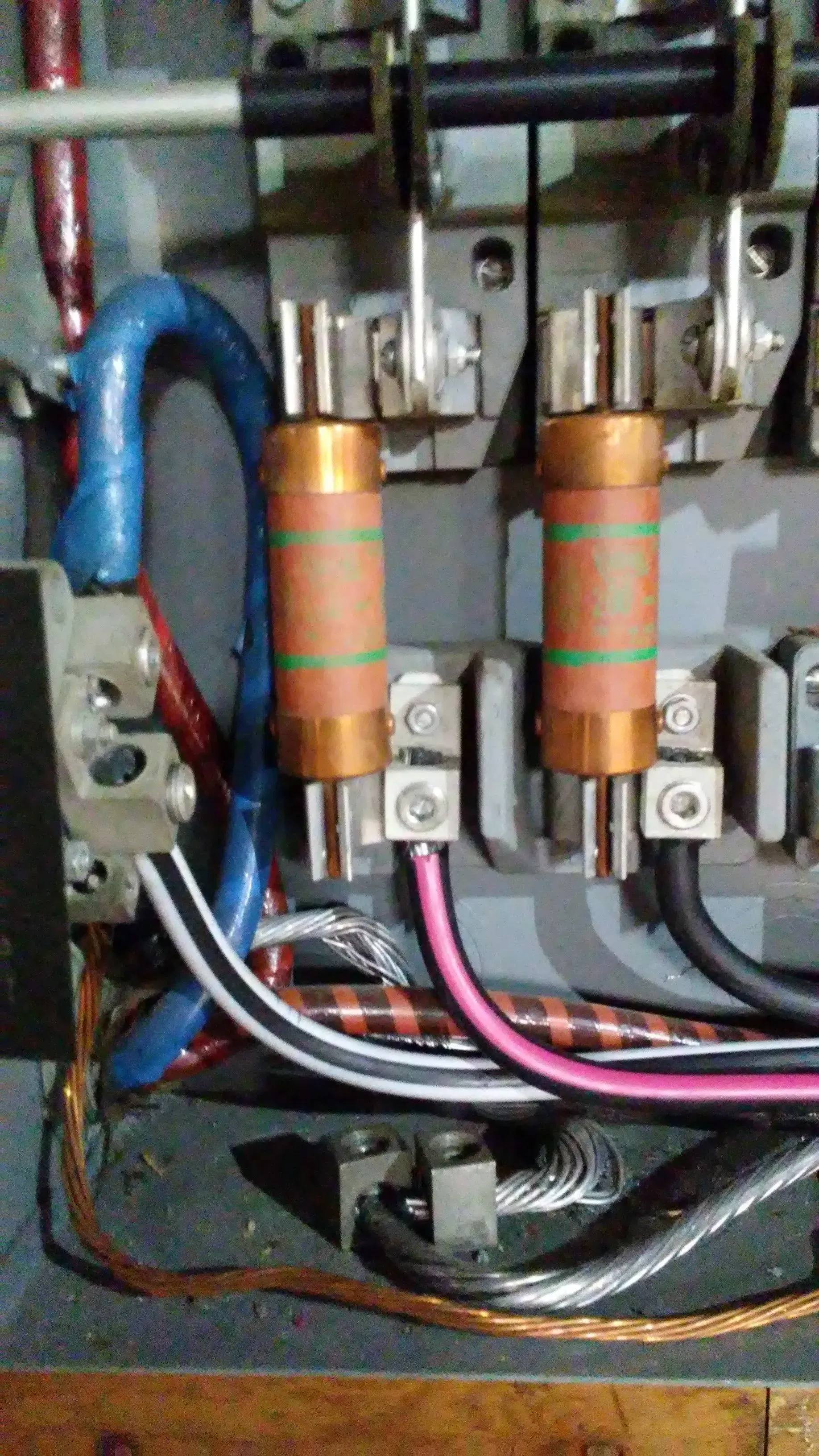 A close up of a electrical box with a bunch of wires and fuses.