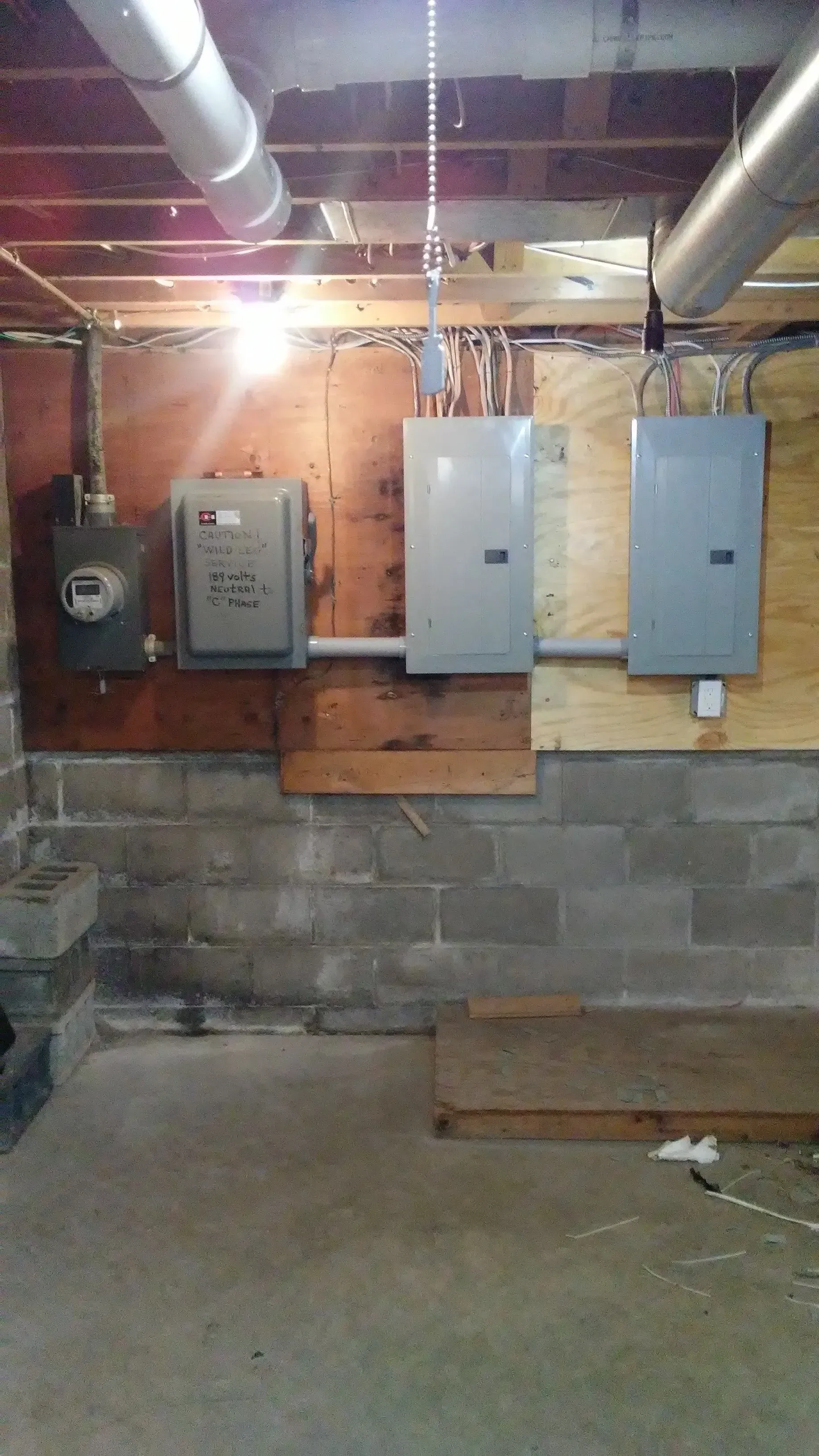 A basement with a lot of electrical boxes on the wall.