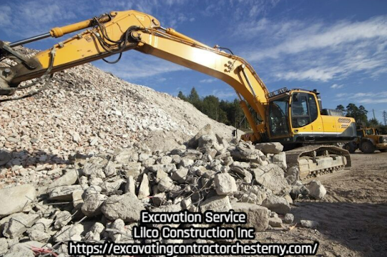 Yellow excavator at work, moving debris. Outdoors, blue sky.