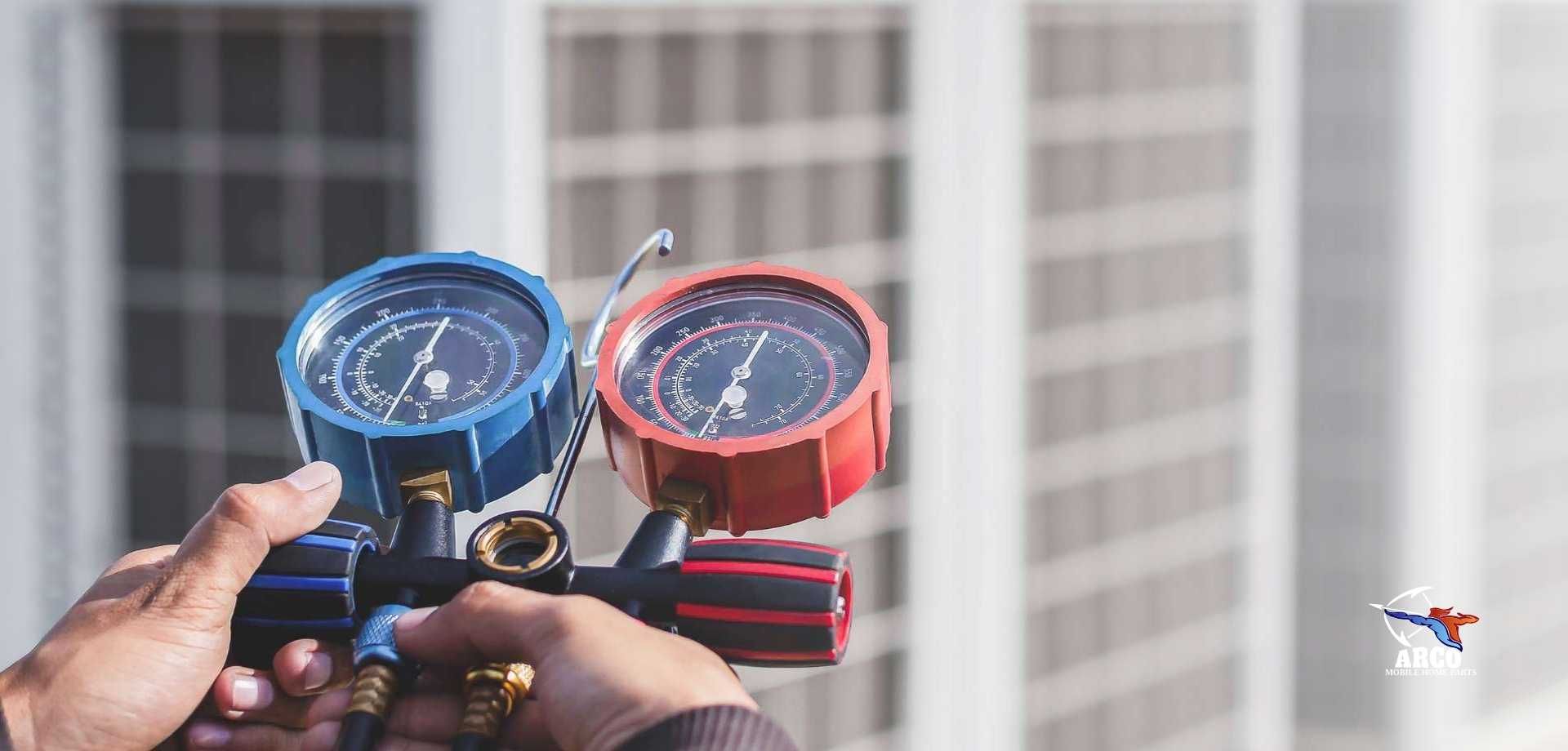 A person is holding two gauges in their hands in front of a building.